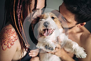 Cheerful and happy couple and the dog, smiling and showing tongu