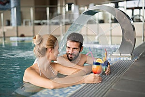 Cheerful happy couple relaxing in swimming pool