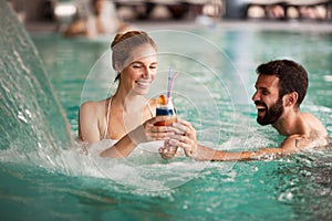 Cheerful happy couple relaxing in swimming pool