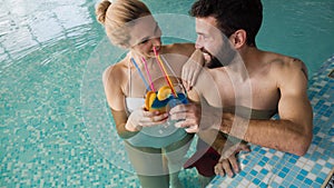 Cheerful happy couple relaxing in swimming pool