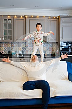 cheerful and happy dad and son fool around and play at home. family happiness.