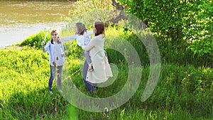 Cheerful happy family having a picnic and playing inflate soap bubbles.