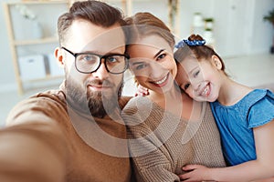 Cheerful happy family mother father and child take selfies, take pictures