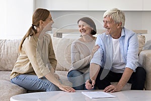 Cheerful happy mature older couple signing papers, investment documents