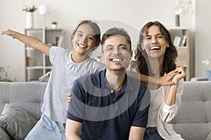 Cheerful happy parents and kid with open arms having fun