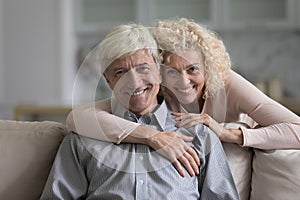 Cheerful happy senior retired married couple home portrait