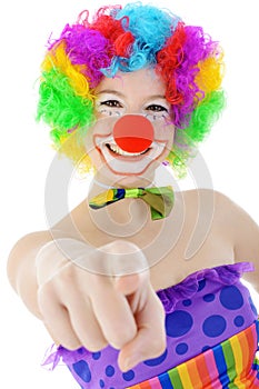 Cheerful happy smiling clown points at viewer in studio