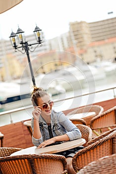 Cheerful happy smiling pretty female in restaurant on luxury marina background.