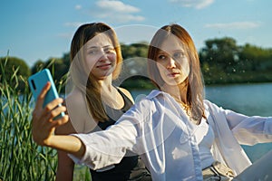 Cheerful happy women in nature take selfie by smartphone