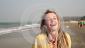 Cheerful hippie girl is walking and dancing on the beach. Portrait of a hippie woman