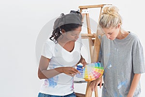 Cheerful housemates choosing colour for wall