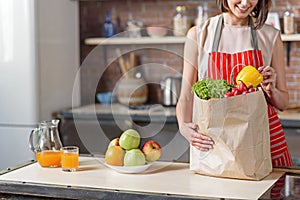 Cheerful housewife holding shopping package