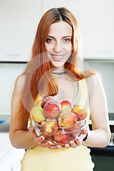 Cheerful houswife holding peaches
