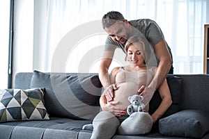 Cheerful husband taking care of his pregnant wife