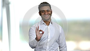 Cheerful Indian businessman showing OK sign.