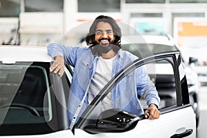 Cheerful indian man holding key from auto, buying new car