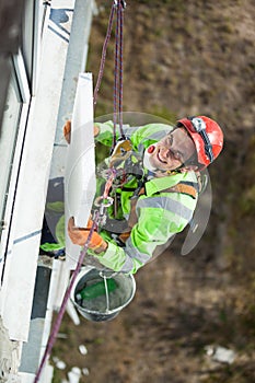 Cheerful industrial climber with styrofoam board during winterization works photo