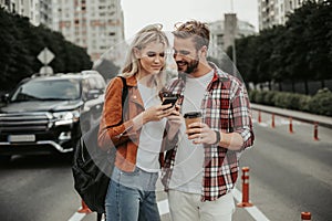 Cheerful interested young couple standing on street
