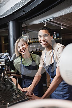 Cheerful interracial baristas looking at camera