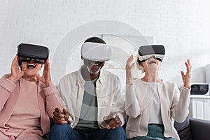 Cheerful interracial pensioners using vr headsets