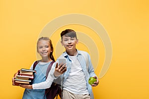 Cheerful interracial schoolkids holding books 