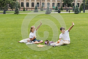 Cheerful interracial schoolkids holding sandwiches and