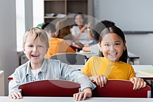 cheerful interracial schoolkids looking at camera