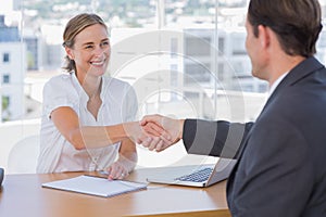 Cheerful interviewer shaking hand of an interviewee photo