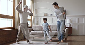 Cheerful joyful multi generation men family dancing at home