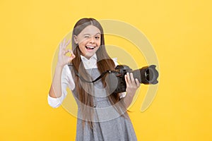 cheerful kid girl take photo with digicam show ok gesture, photography