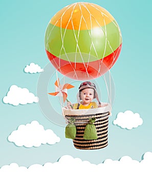 Cheerful kid on hot air balloon in the sky