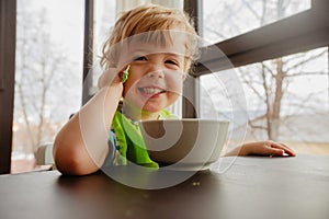 Cheerful kid sitting with plate