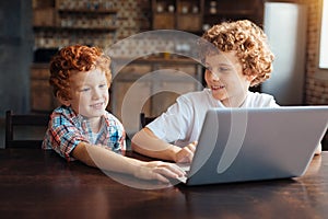 Cheerful kids playing on laptop together