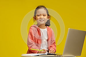 Cheerful Korean Toy with Bright Smile Engages in Learning sitting over isolated background. Sprightly Chinese Child