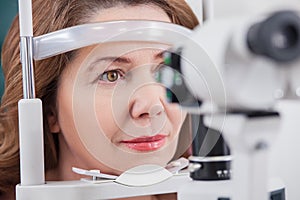 Cheerful lady having eye examination in oculist office