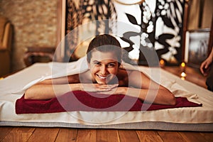 Smiling woman in massage centre with hands under her head