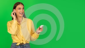 Cheerful Lady Listening To Music Via Earbuds Over Green Background