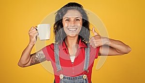 cheerful lady in shirt denim style drinking morning coffee on yellow background, perfect morning