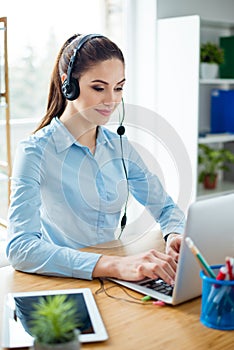 Cheerful lady from telemarketing is typing the data in compute ,