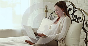 Cheerful late pregnant woman using laptop computer