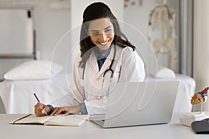 Cheerful Latin doctor woman talking to patient on video call