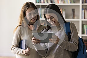 Cheerful Latin student girl showing learning online presentation on tablet