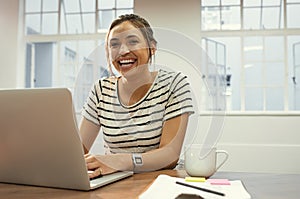 Cheerful latin woman using laptop photo