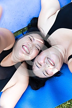 Cheerful laugh smiling friends young asian woman happy embrace in sportswear walking after exercise. Two sporty women body curvy