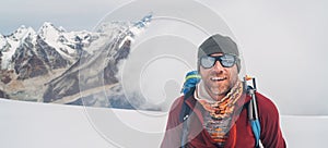 Cheerful laughing climber in sunglasses portrait with backpack ascending Mera peak high slopes at 6000m enjoying legendary Mount