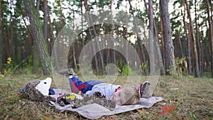 cheerful little baby boy plays with cones and other toys on carpet in the wood.