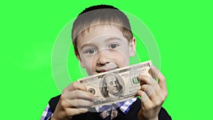 Cheerful little boy close-up, holding dollar