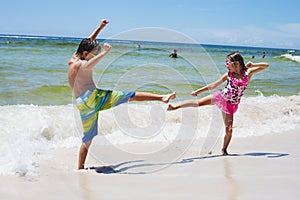 Cheerful little boy and girl playing on beach