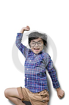 Cheerful little boy jumping in the studio