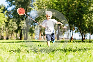 Cheerful little boy running in the park